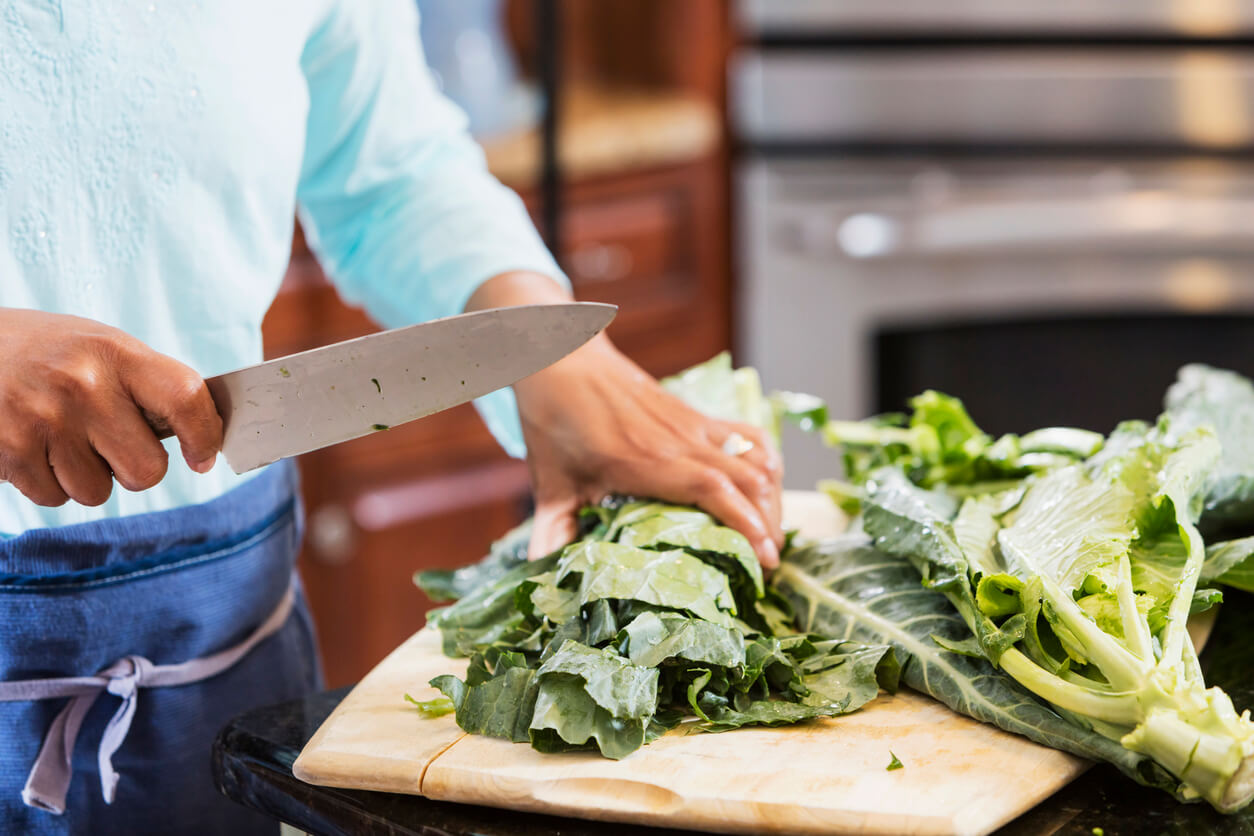 woman chopping collard greens on cutting board