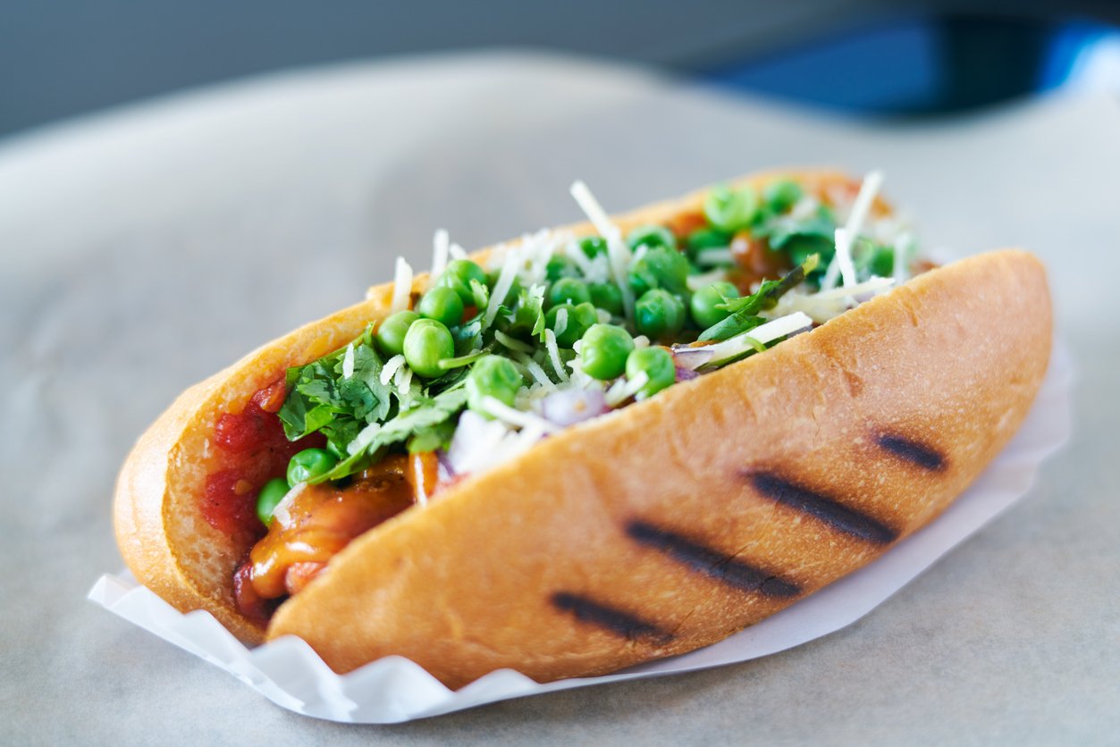 tasty vegan meatless hot dog with peas and vegetables shot with selective focus