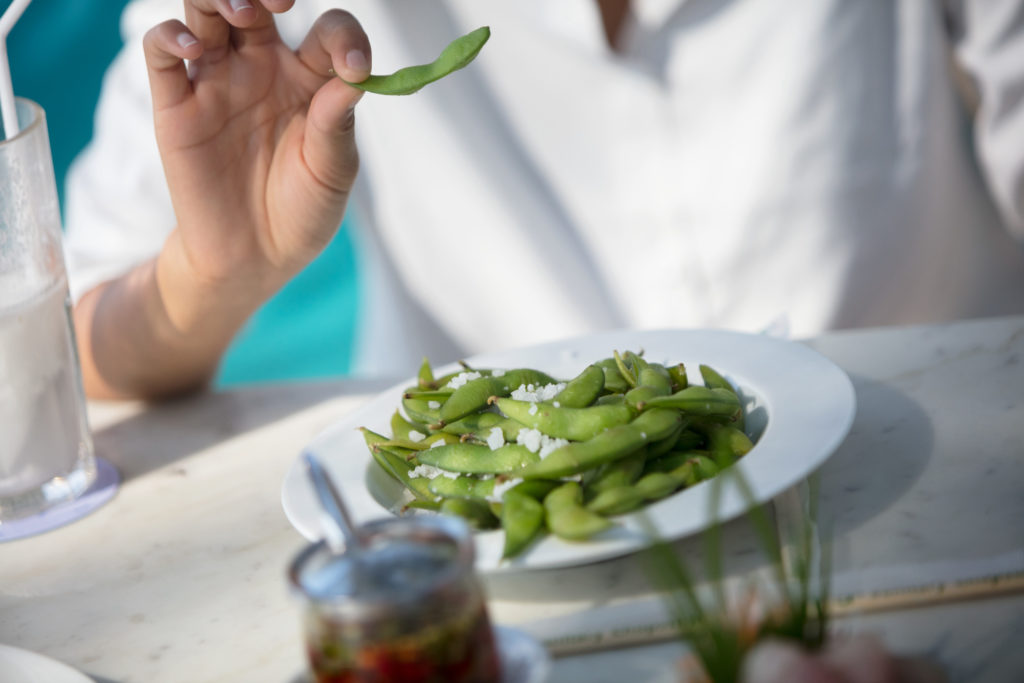 Hand pushing away edamame which contains phytoestrogens