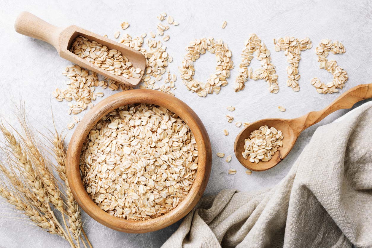 rolled oats in wooden bowl and spelling out the word oats