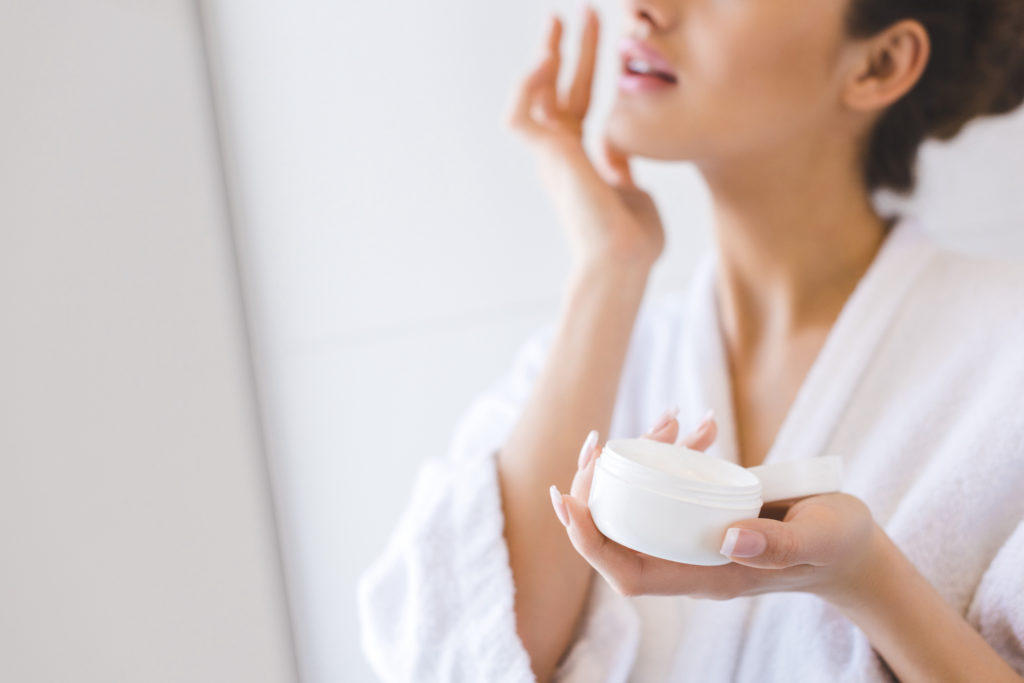 woman putting on anti-aging skin care cream