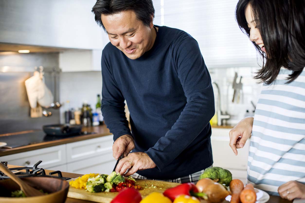asian couple cooking in kitchen