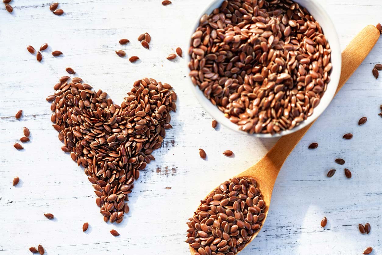 flaxseeds in bowl and on table in shape of heart