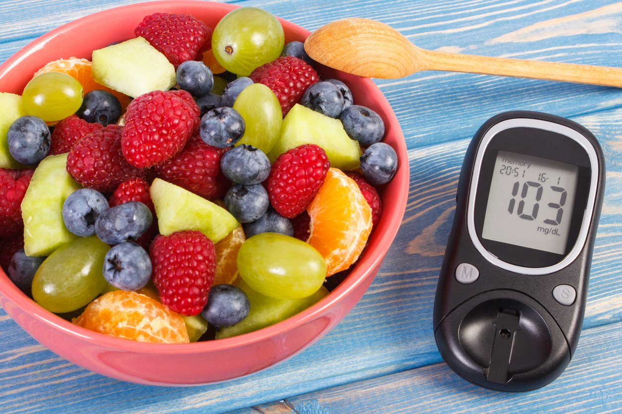 Fruit salad and glucometer with result of measurement sugar level, concept of diabetes, diet, slimming, healthy lifestyles and nutrition