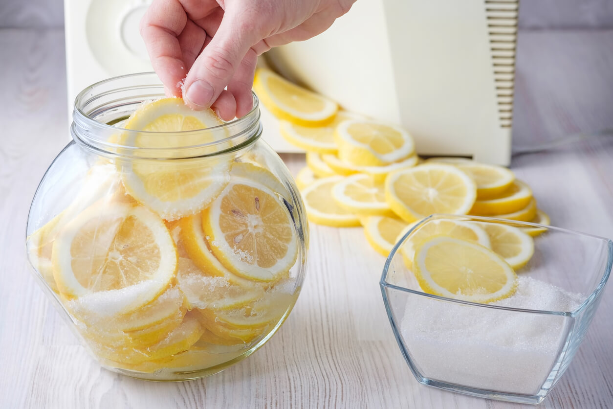 woman's hands puts a slice of lemon in a can