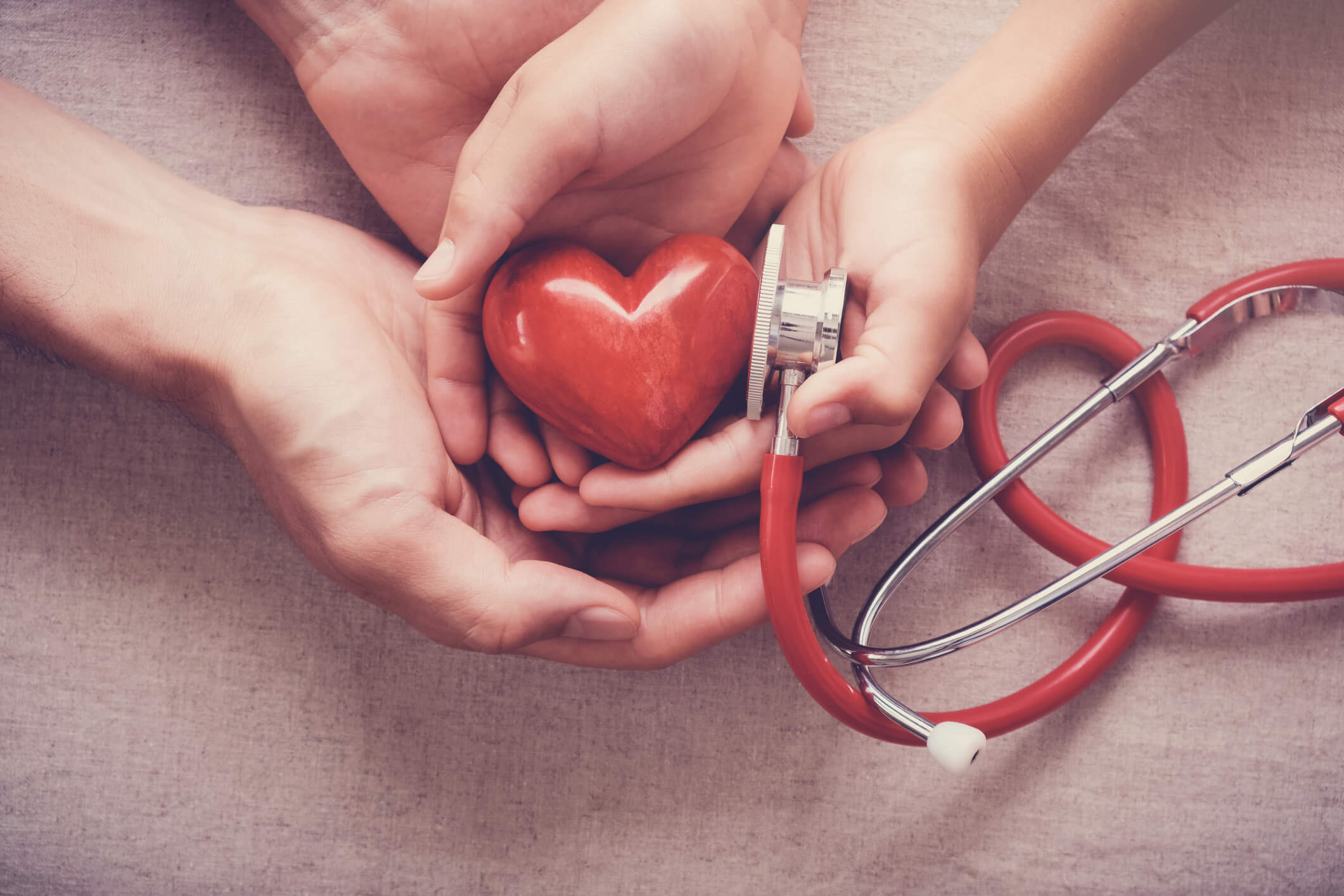 Hands holding a heart with stethoscope