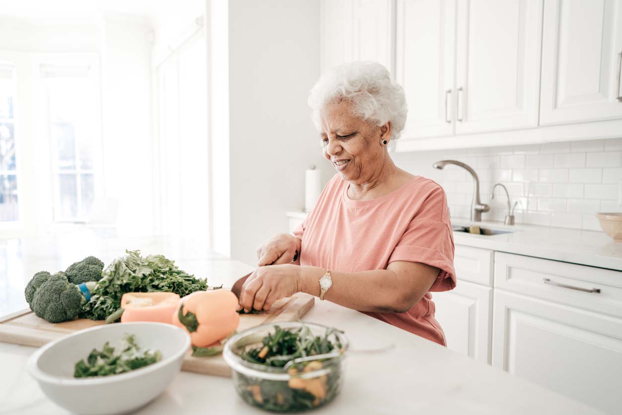 elderly woman preparing green vegetables