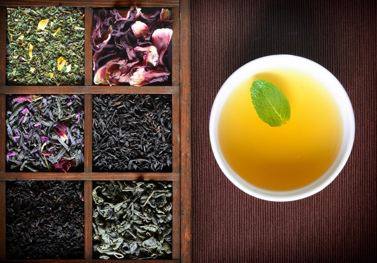 dry tea assortment in wooden box with white cup