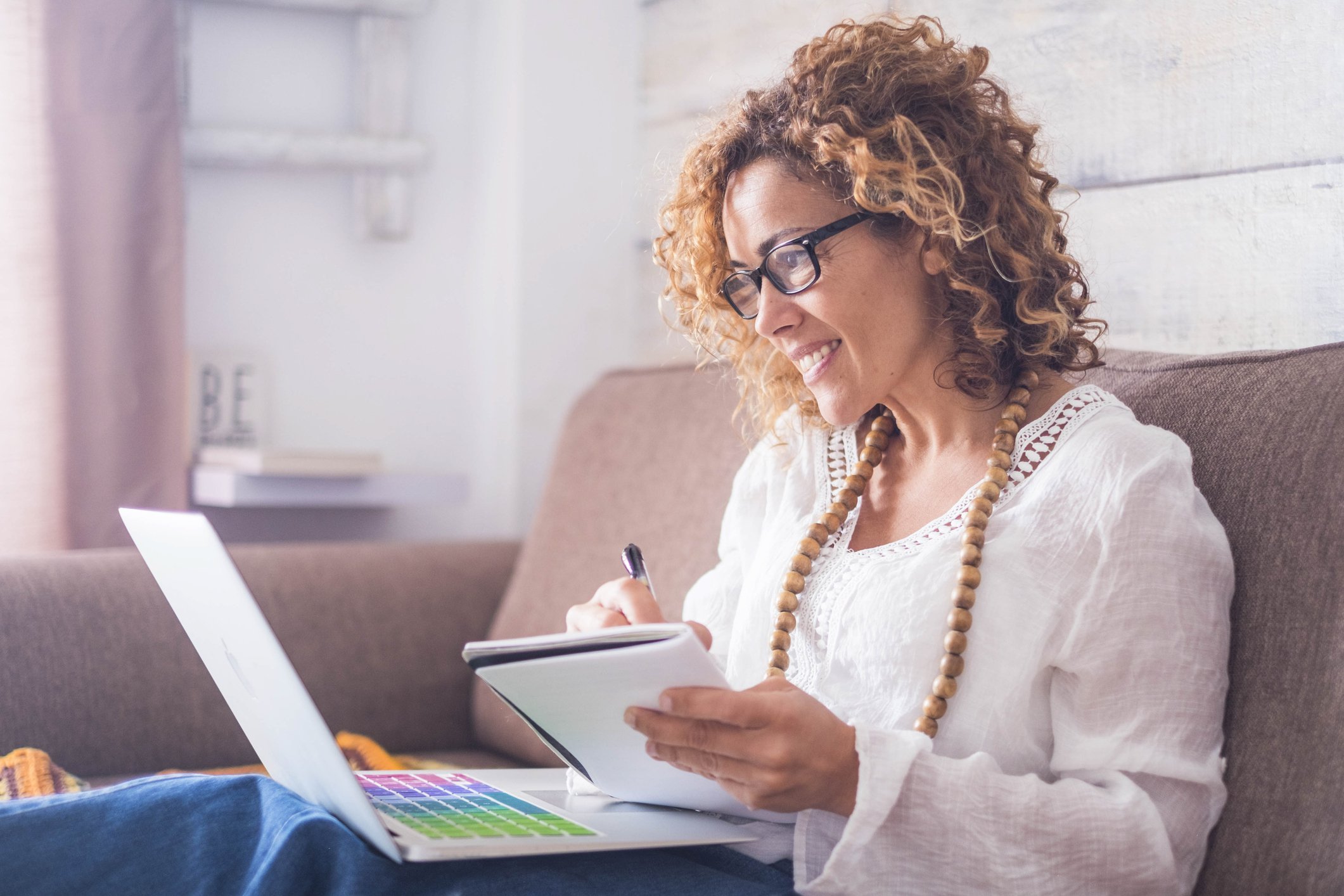 Woman writing notes from her laptop