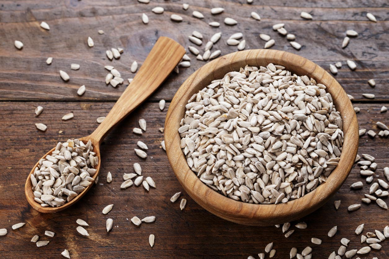 peeled sunflower seeds in wooden bowl