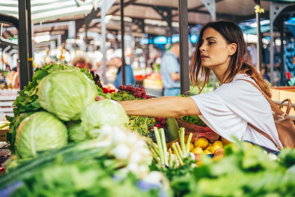 Woman choosing cabbage at market