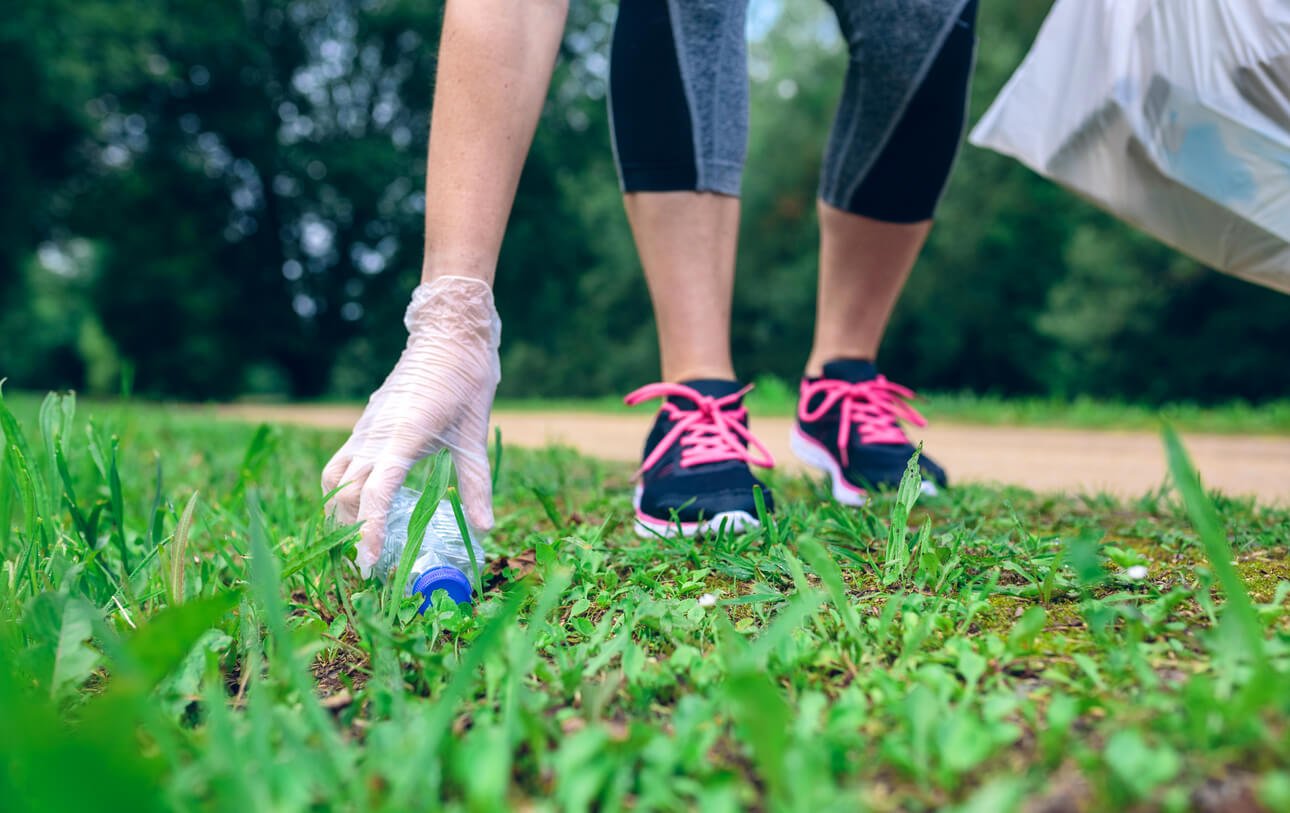 plogging girl hand picking up garbage