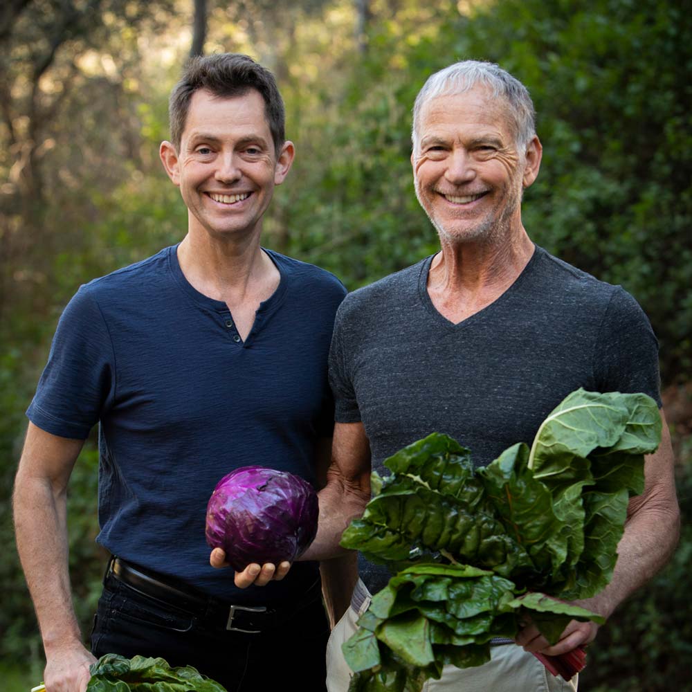 John and Ocean Robbins holding veggies