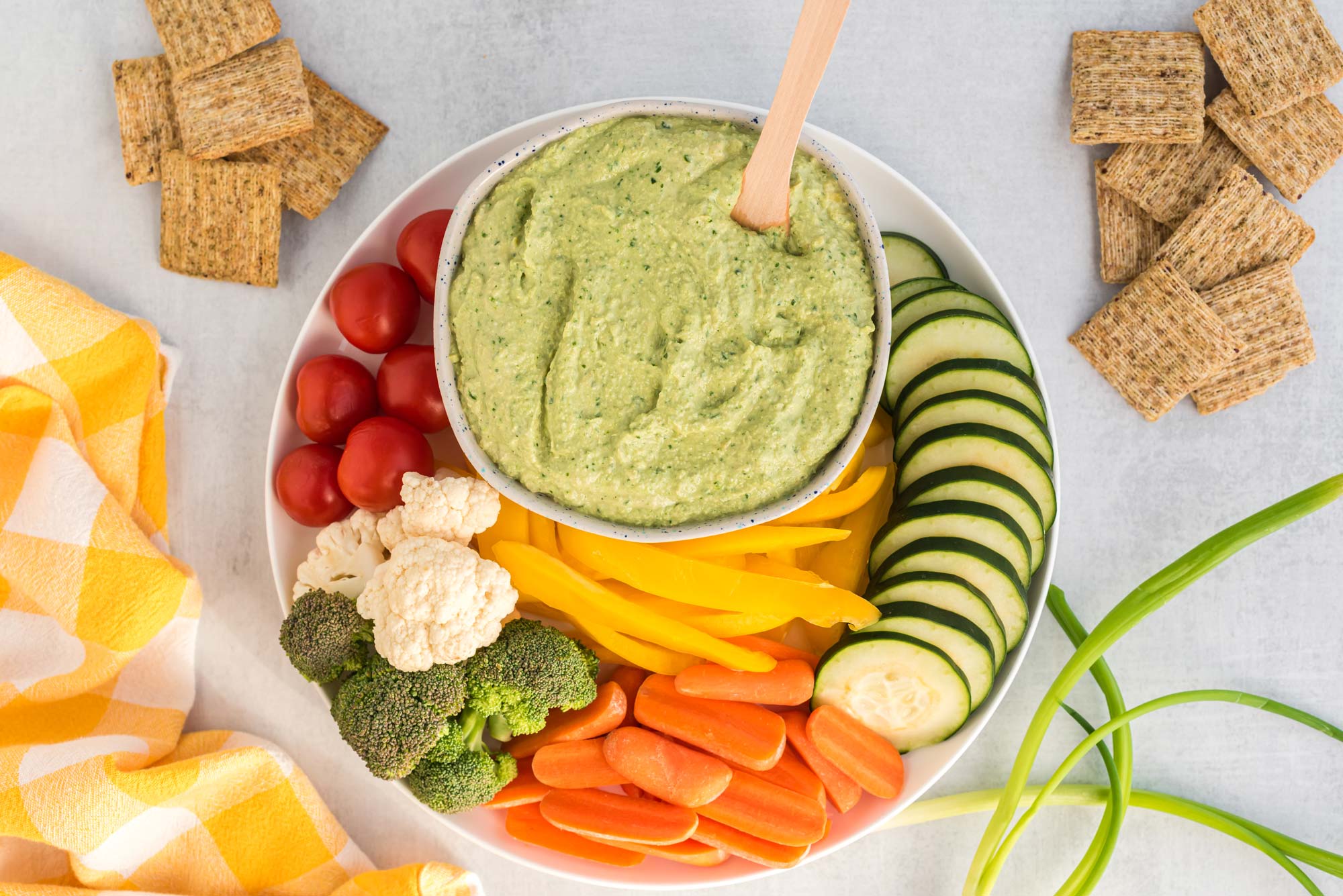 spinach artichoke dip with cut veggies on plate